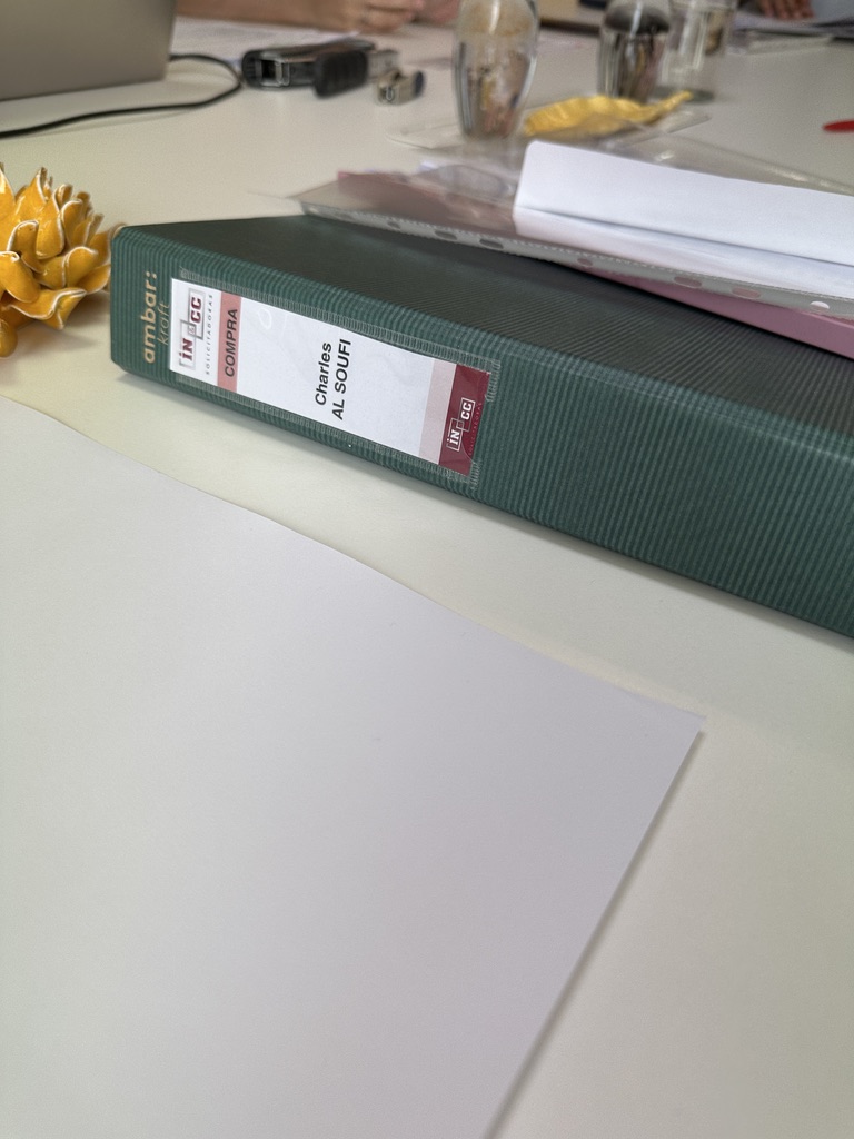 The purchase paperwork binder on the lawyer’s meeting table